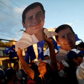 Los partidarios de Hernández sostienen figuras del candidato a la reelección mientras esperan los resultados oficiales de las elecciones presidenciales en Tegucigalpa. / Reuters
