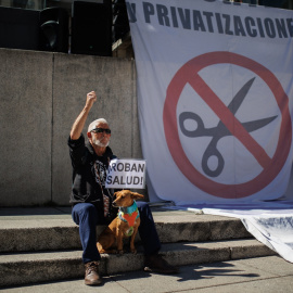 Un manifestante sostiene un cartel que dice 'Roban salud' en la 98ª Marea Blanca por la Sanidad Pública, en la plaza de Juan Goytisolo, a 19 de marzo de 2023, en Madrid, (España).