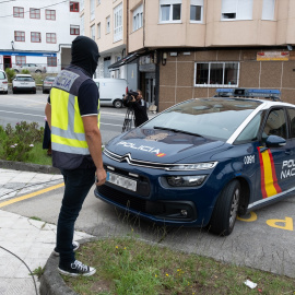 Un agente y un coche de la Policía Nacional. Imagen de archivo.