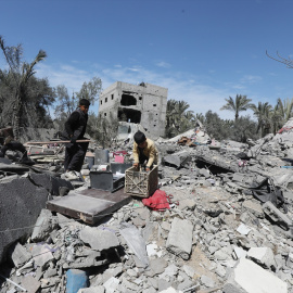 15/03/2024 Varios palestinos tratan de recoger sus pertenencias utilizables alrededor de los restos tras un ataque israelí en Dair El-Balah, Gaza, a 13 de marzo de 2024.