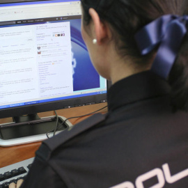 Agente de la Policía Nacional escribiendo en la cuenta de Twitter @policia. (EFE)
