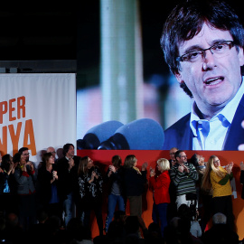 El president destituido Carles Puigdemont aparece en una pantalla durante el mitin de comienzo de la campaña electoral para el 21-D de Junts per Catalunya, en Barcelona. REUTERS/Javier Barbancho