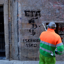 Un emlpeado municipal limpia en Bilbao una pintada que dice, en vasco, 'ETA gracias', dos días después del anuncio de disolución de la organización terrorista. REUTERS/Vincent West