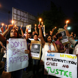 La gente sostiene velas y pancartas durante una protesta contra la violación de una niña de ocho años en Kathua/Reuters