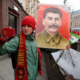 Un hombre se fotografía junto a un retrato de Stalin./REUTERS