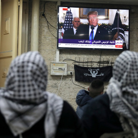 Palestinos escuchan el discurso de Trump en el que reconoce oficialmente a Jerusalén como capital de Israel. REUTERS/Ammar Awad