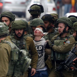 Soldados israelíes detienen a un manifestante durante unas protestas contra la decisión del presidente estadounidense, Donald Trump, de reconocer a Jerusalén como capital de Israel, en la ciudad cisjordana de Hebrón (Palestina).- EFE/ Abed Al Hashlamo