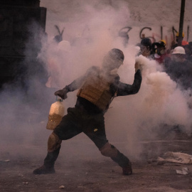 Un manifestante choca con la policía antidisturbios durante una protesta contra el gobierno de la presidenta peruana Dina Boluarte