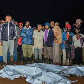 Personas alrededor de los cádaveres en un área residencial al norte de Nakuru - AFP