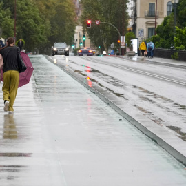 Dos personas caminan con dificultad por Sevilla debido al viento y la lluvia, a 19 de octubre de 2023.