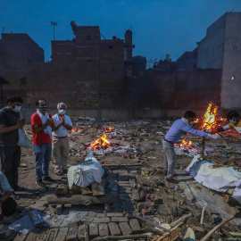 Imagen de archivo de varias personas incinerando a fallecidos por la covid-19, en India. - EFE