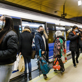 Varias personas bajan y suben de un metro en el andén de la estación de Metro de Callao, a 26 de enero de 2023, en Madrid (España).