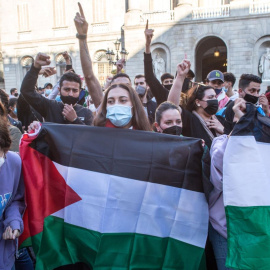 Varios manifestantes sostienen banderas palestinas durante una protesta contra el Estado de Israel frente a la sede de la Generalitat de Catalunya, a 10 de mayo de 2021, en Barcelona.