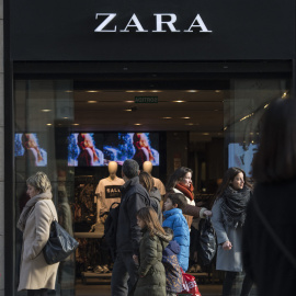 Varios transeúntes pasan por delante de una tienda de Zara anunciando descuentos en el primer día de las rebajas de invierno en Barcelona. el 7 de enero de 2017.
