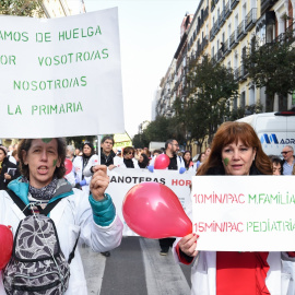 Dos mujeres con bata blanca y pancartas durante una concentración de médicos y pediatras de Atención Primaria en huelga, desde la sede de la Dirección General de Recursos Humanos del Servicio Madrileños de Salud, a 22 de febrero de 2023, en Madrid (E