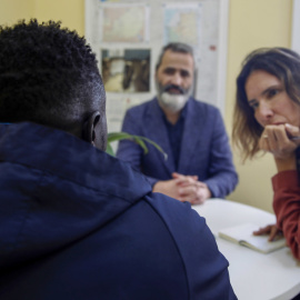 Basir, el joven sudanés (en la imagen de espaldas), que pidió asilo hace casi tres meses en la Embajada de España en Rabat, junto a su abogado Arsenio Cores (c), y la delegada de la Agencia EFE en Marruecos María Traspederne (d), durante la entrevista
