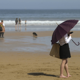 Playa de San Lorenzo de Gijón, este domingo, con las temperaturas en ascenso en todo el país.