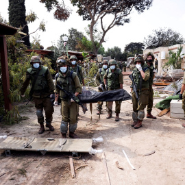 Soldados israelíes llevan el cuerpo de una de las víctimas del ataque de milicianos de Hamás al Kibbutz Kfar Aza, en el sur de Israel. REUTERS/Ronen Zvulun