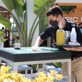 Un camarero de un restaurante de Sitges limpiando la mesa entre servicios de aperitivo