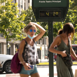 Varias personas pasean por el centro de Zaragoza en plena ola de calor marcando los termómetros hasta 41º.
