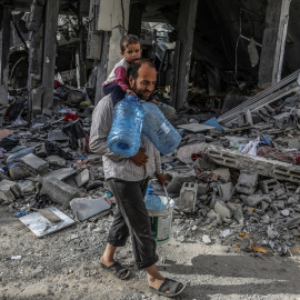 26/04/2024 Un palestino y su hijo caminan junto a una casa destruida tras un ataque aéreo israelí, a 25 de abril de 2024.