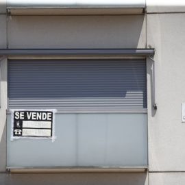 Cartel de 'se vende' en el balcón de un piso de un edificio de Madrid.