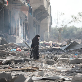 Una mujer busca entre los restos de su casa en Ciudad de Gaza tras un bombardeo israelí
