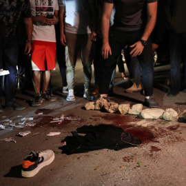 Varias personas se reúnen frente a un charco de sangre en el lugar donde dos palestinos resultaron heridos a causa de los enfrentamientos, a 19 de junio de 2023.