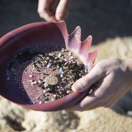 Voluntarios recogen microeplásticos o pellets, que han aparecido en toda la costa atlántica de Galicia, este domingo en la Playa de A Lanzada en O Grove.
