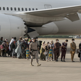 Varias personas, entre ellas niños llegan a la base aérea de Torrejón de Ardoz.