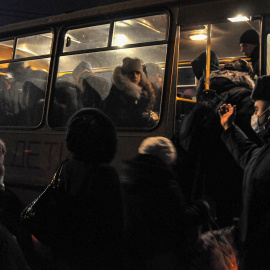 residentes locales de la autoproclamada República Popular de Donetsk se suben a un autobús para ingresar a Rusia en el puesto aduanero 'Matveev Kurgan' en la región de Rostov, Rusia, el 19 de febrero de 2022.