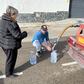 Una veïna omplint garrafes d’aigua