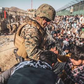 Un soldado de EEUU atiende a civiles afganos en el plan de evacuación en el aeropuerto de Kabul.