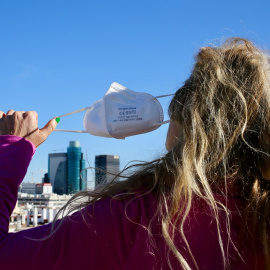 Una mujer se quita la mascarilla, a 8 de febrero de 2022, en Madrid.