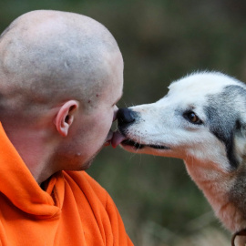 Un perro besa a su dueño.