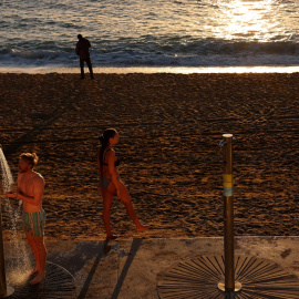 Una persona se ducha en la playa de la Barceloneta, en Barcelona, en mitad de enero.