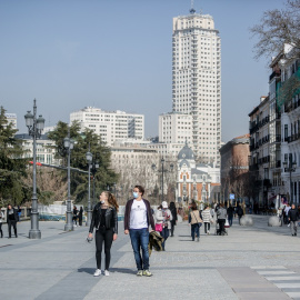 Una mujer camina sin mascarilla y un hombre con mascarilla, a 10 de febrero de 2022, en Madrid