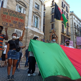 La comunitat afgana sosté una bandera gegant de l'Afganistan durant la mobilització a la plaça Sant Jaume de rebuig contra l'emirat proclamat pels talibans.