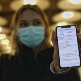 Una mujer de nacionalidad francesa enseña el negativo de su PCR en la terminal T4 del Aeropuerto de Madrid-Barajas Adolfo Suárez, en Madrid (España),