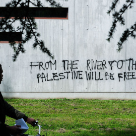 Un ciudadano francés frente a una pintada que dice: "Desde el río hasta el mar, Palestina vencerá", a 30 de abril de 2024.