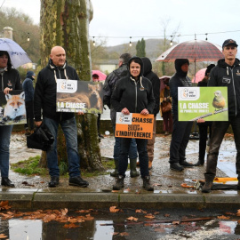 Manifestantes contra la caza sostienen pancartas durante una marcha blanca para rendir homenaje al joven, un año después de que fuera asesinado por un cazador, en Cajarc