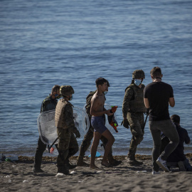 Un menor llega a nado por la playa de Tarajal en Ceuta.