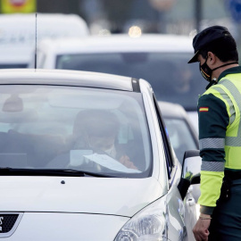 Un agente de la Guardia Civil le pide la documentación al conductor de un vehículo durante un control efectuado en Laredo, Cantabria