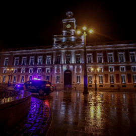 Un coche de la Policía Nacional circula en la Puerta del Sol durante la primera noche de toque de queda en Madrid