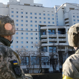 Los militares ucranianos miran un edificio residencial dañado, después de que Rusia lanzó una operación militar masiva contra Ucrania, en Kiev, Ucrania, el 26 de febrero.