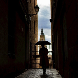 Una mujer pasea por Toledo bajo la lluvia.
