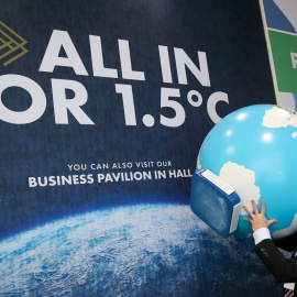 Una persona carga con un globo terráqueo durante la Cumbre del Clima de Glasgow (COP26).