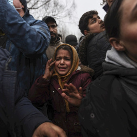 Migrantes se reúnen para que los militares bielorrusos distribuyan ayuda humanitaria en el campo de la frontera entre Bielorrusia y Polonia en la región de Grodno, no lejos del puesto de control de Bruzgi, Bielorrusia, 11 de noviembre de 2021.