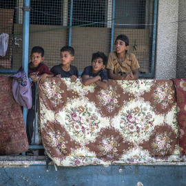Niños palestinos desplazados en un balcón de la escuela de la UNRWA destruida por los bombardeos de Israel.