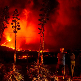 Una pareja vecinos de Los Llanos de Aridane observan como la colada se adentran en el barrio de La Laguna en la madrugada del jueves.